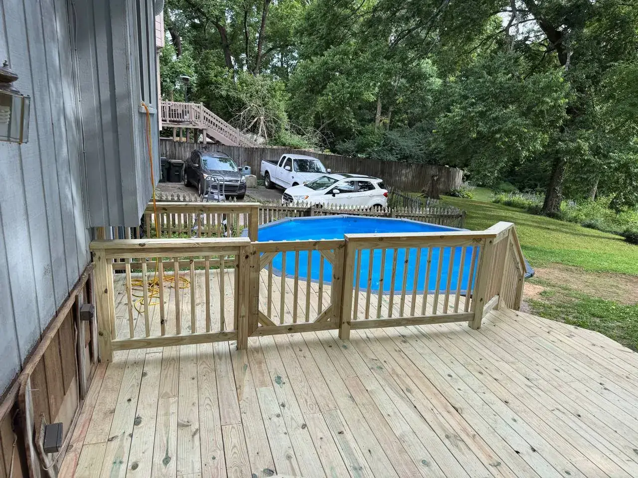 Pressure-treated deck gate and railing beside a pool