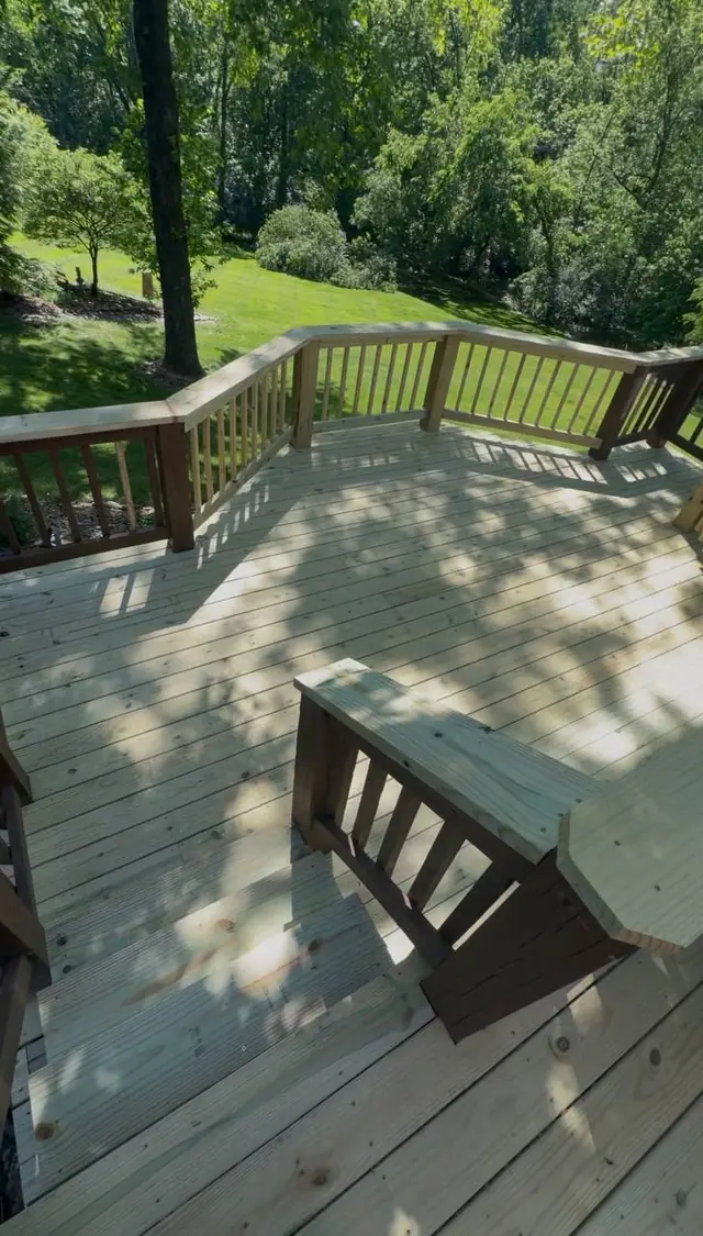 Finished middle-level pressure treated decking and new wood railings viewed from the stairs