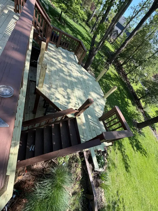 Completed middle-level deck boards and exposed railing posts, with the original stair top rails still in place